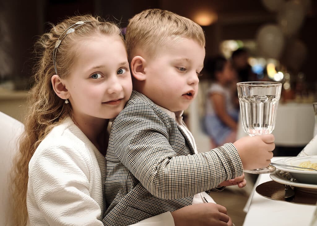 Reportaż Komunijny - dzieci podczas przyjęcia siedzące przy stole