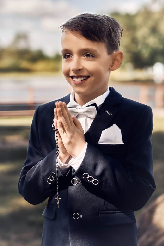 Sesja Komunijna - uśmiechnięty chłopiec z różańcem