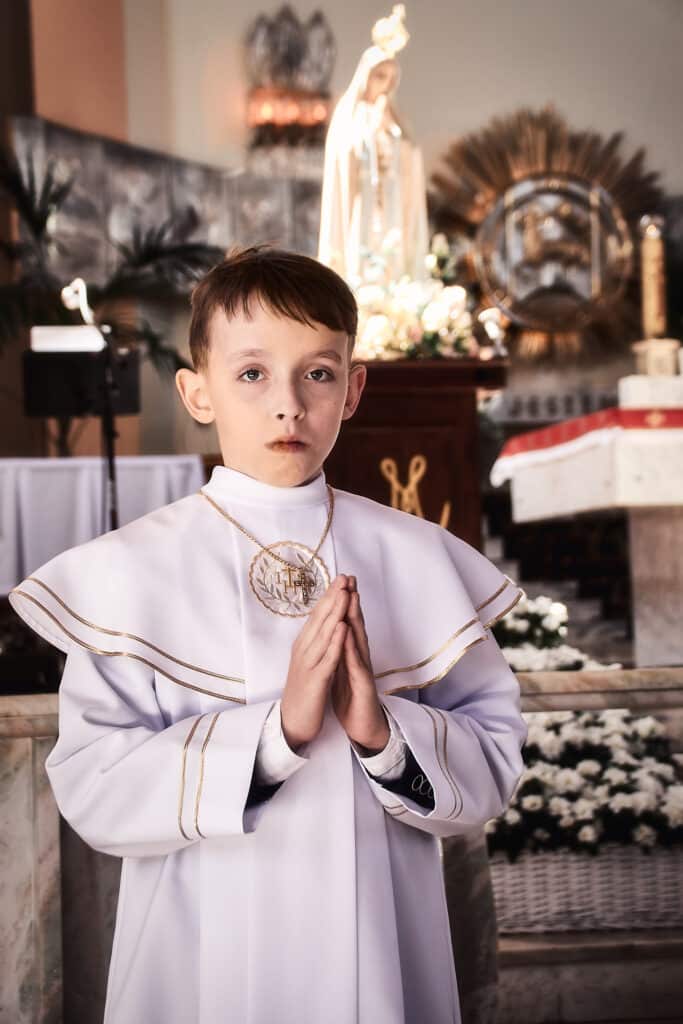Chłopiec pierwszokomunijny modlący się w kościele Kolbego