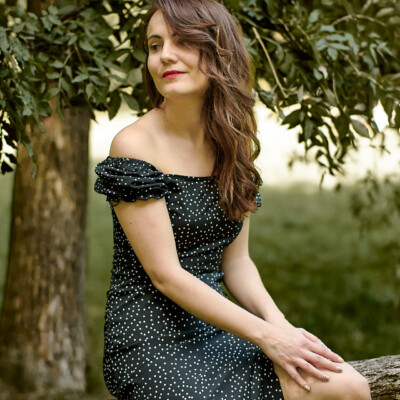 Modelka siedząca na drzewie podczas sesji portretowej