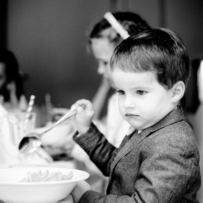 Zamyślony, poważny chłopiec podczas przyjęcia Komunijnego