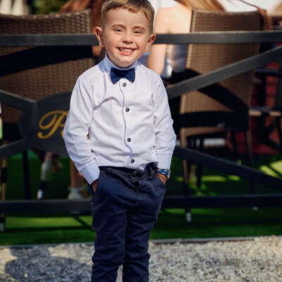 Uroczy chłopiec z rękami w kieszeniach - reportaż komunijny