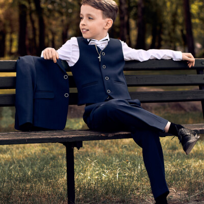Chłopiec pierwszokomunijny siedzi na ławce - sesja fotograficzna