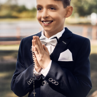 Sesja Komunijna - uśmiechnięty chłopiec z różańcem