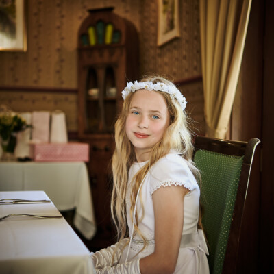 Pierwszokomunijna dziewczynka za stołem