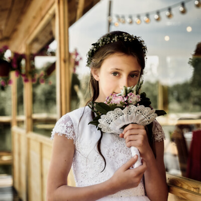 Dziewczynka Pierwszokomunijna pozuje z bukietem