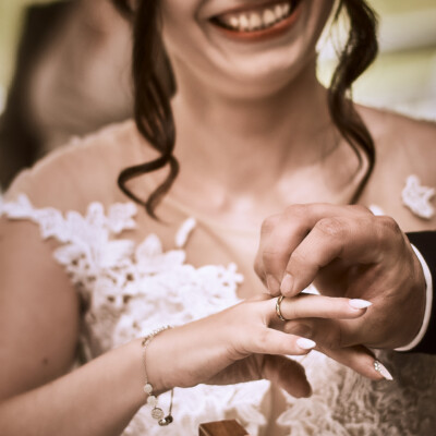 Pan Młody zakłada obrączkę Pani Młodej.